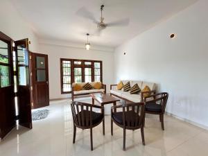Una sala de estar con una mesa y sillas y un sofá. en Wind Haven Yala, en Tissamaharama