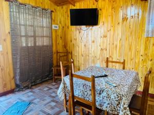 a room with a table and a television on a wooden wall at Portal del sol in Puerto Iguazú