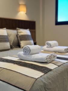 three stacks of towels sitting on top of a bed at Iguazu Lofts in Puerto Iguazú
