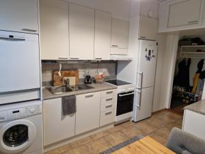 a white kitchen with a sink and a refrigerator at Kaksio Kimpisessä in Lappeenranta +5 photos