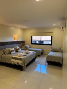 a bedroom with two beds and a window at Iguazu Lofts in Puerto Iguazú