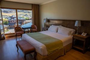 a hotel room with a bed and a balcony at Chalten Suites Hotel in El Chalten