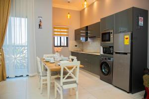 a kitchen with a table and a dining room at D'Magnolia Luxury Apartments in Ogbojo