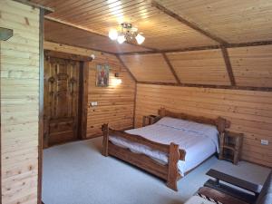 a bedroom with a bed in a log cabin at Zatyshok v Karpatah in Vorokhta