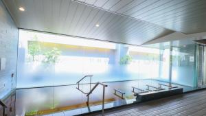 a lobby with glass walls and stairs in a building at Dormy Inn Kanazawa Natural Hot Spring in Kanazawa