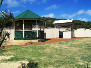 a gazebo with a green roof in a yard at Ocean View Villas in Geraldton