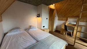 a bedroom with a bed and a desk with a chair at Domek Góralski Reset in Gliczarów Górny