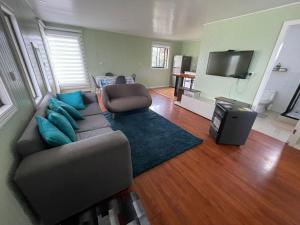 ein Wohnzimmer mit Sofa und Fernseher in der Unterkunft Cabaña El Retiro in Lebu