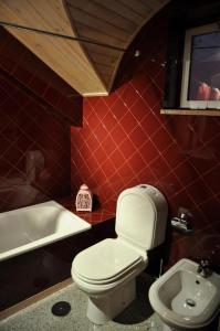 a bathroom with a white toilet and a sink at casa do meio da vila suites in Loriga +4 photos