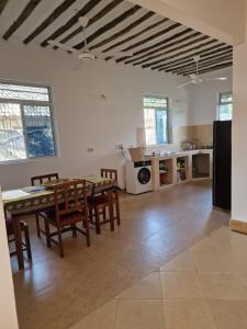 a kitchen and dining room with a table and chairs at Baga Moyo House in Kiwengwa