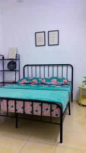 a bed in a room with two posters on the wall at Arrafah Homestay Klebang in Tranquerah