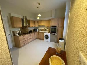 a large kitchen with wooden cabinets and a table in it at La villa Hortense in Valençay