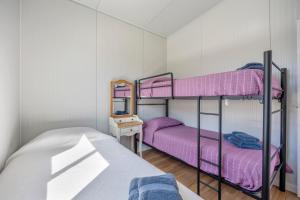 2 Etagenbetten in einem kleinen Zimmer mit violetter Bettwäsche in der Unterkunft Casa Con Jardín y piscina in Chiclana de la Frontera + 22 Fotos