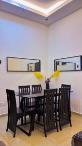 a dining room with a black table and chairs at Arrafah Homestay Klebang in Tranquerah