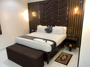 a bedroom with a large bed with a brown headboard at Victorian Bloom Hotel & Resort in Asaba