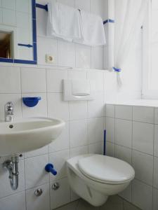 a white bathroom with a toilet and a sink at Gasthaus zum Schloßwirt in Dietfurt +9 photos