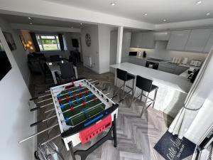 a room with a ping pong table in a kitchen at Amora Stays in Buckinghamshire