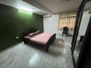 a bedroom with a bed and a green wall at Hi Goa in Sangolda
