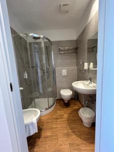 a bathroom with a shower and a toilet and a sink at Hb Hotels Orchidea Blu in Rimini