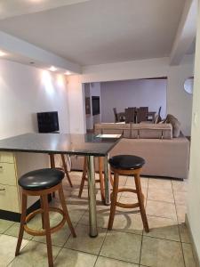 una mesa y taburetes en una sala de estar con sofá en Waterfront E11, en Swakopmund