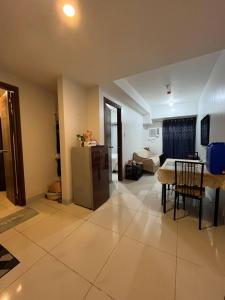 un soggiorno con un tavolo e un frigorifero di 1 BR, Horizon 101, Capitol Site, Cebu City a Cebu City