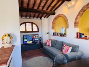 a living room with a couch and a tv at Santa Maria Dreaming Rooftop in Pisa