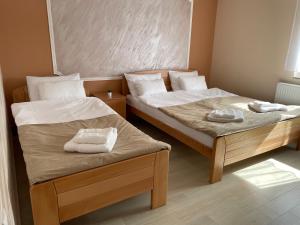 two beds in a small room with towels on them at Sobe Sara in Šabac