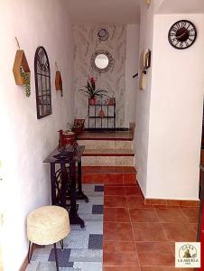 a hallway with a table and chairs and a clock at Casa La Abuela 1982 in La Iruela +22 photos