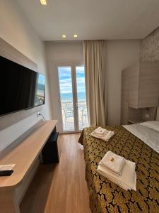 a hotel room with a bed and a large window at Hb Hotels Orchidea Blu in Rimini