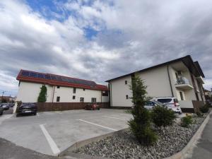 a building with cars parked in a parking lot at 11IunieResidence in Târgu Jiu