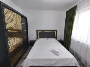 a bedroom with a bed with two towels on it at 11IunieResidence in Târgu Jiu