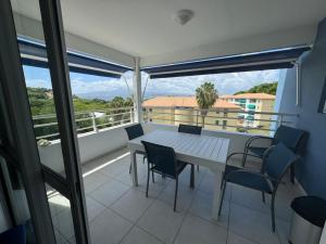 a table and chairs on a balcony with a view at La perle de l anse in Les Trois-Îlets