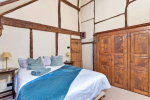a bedroom with a large bed with blue pillows at Finest Retreats - Sandhill Cottage with hot tub in Turners Hill