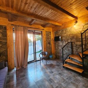 a living room with a couch and a stair case at Iveria Parky and cottages in Shekhvetili