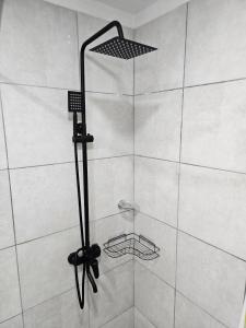 a shower with a black shower head in a bathroom at Departamento moderno en el centro de Posadas in Posadas +8 photos