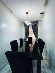 a dining room with chairs and a table and a window at Gambette Apartment in Ibadan