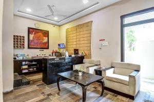 a living room with a table and a chair at Super Townhouse All In One in kolkata