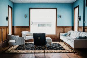 a living room with blue walls and a couch and chairs at The Loyalist Inn & Suites in Shelburne +1 photo