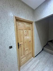 a wooden door in a room with a bed at Houssam immobilier 7 in Souira Guedima