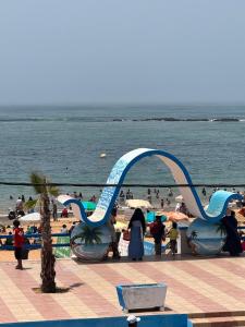 a group of people on a beach with a water slide at Houssam immobilier 7 in Souira Guedima