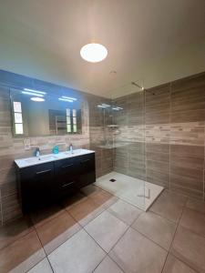 a bathroom with a sink and a glass shower at Maison de la Fontaine - Typique - Bourg de Collonges in Collonges la rouge