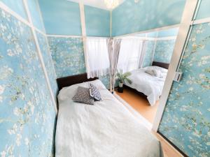a bedroom with a bed in a room with blue walls at Shinjuku, 3min walk from Nishi-Shinjuku 5-chome Sta, 3min Shinjuku Sta Switch, Wi-Fi ,Pocketwi-Fi in Tokyo