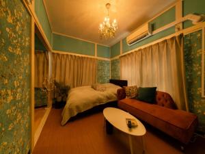 a bedroom with a bed and a couch and a table at Shinjuku, 3min walk from Nishi-Shinjuku 5-chome Sta, 3min Shinjuku Sta Switch, Wi-Fi ,Pocketwi-Fi in Tokyo