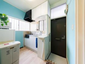 a kitchen with blue walls and a black door at Shinjuku, 3min walk from Nishi-Shinjuku 5-chome Sta, 3min Shinjuku Sta Switch, Wi-Fi ,Pocketwi-Fi in Tokyo