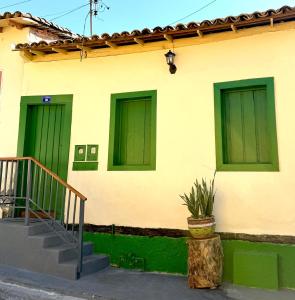 a building with green doors and a potted plant at Casa Noites Goianas in Goiás