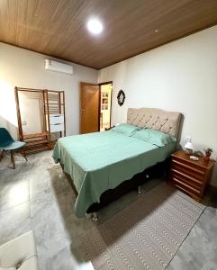 a bedroom with a bed with a green comforter at Casa Noites Goianas in Goiás +33 photos