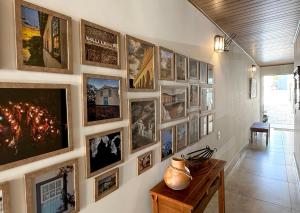 a hallway with a bunch of pictures on a wall at Casa Noites Goianas in Goiás