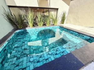 a swimming pool with blue tiles on the side of a building at Casa Noites Goianas in Goiás