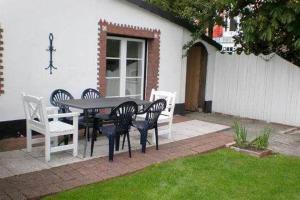 a patio with a table and chairs in a yard at Ferienhaus-„Alte-Schmiede“ in Westerland (Sylt)