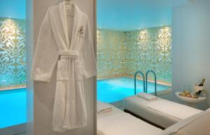 a bathroom with a bed and a bath room with a pool at Hôtel Kleber Paris & Spa in Paris